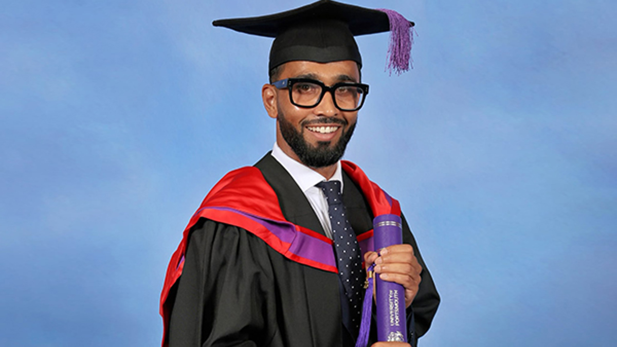 Portrait of article author Muzammil Rafi in graduation robes holding a degree certificate.