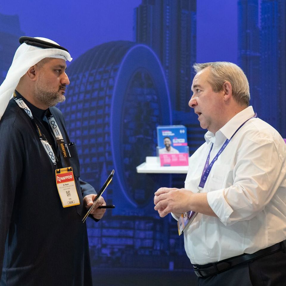 Two men in discussion at IOSH stand during Intersec Dubai 2026 exhibition