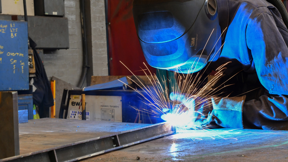 Worker wearing personal protective equipment doing some welding