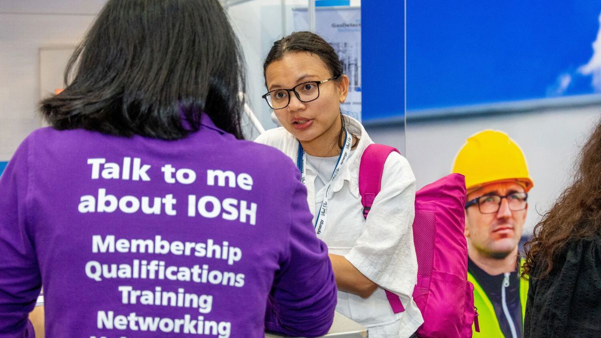 IOSH staff member wearing t-shirt saying Talk to me about IOSH on the back