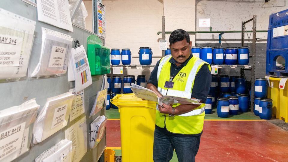 Man in high-vis jacket looking at folder