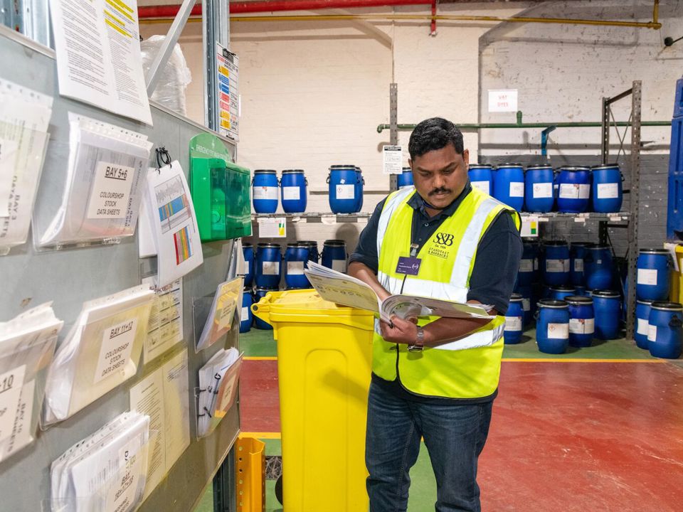 Man in high-vis jacket looking at folder
