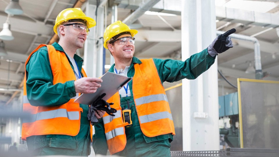 Two workers in full personal protective equipment (PPE)