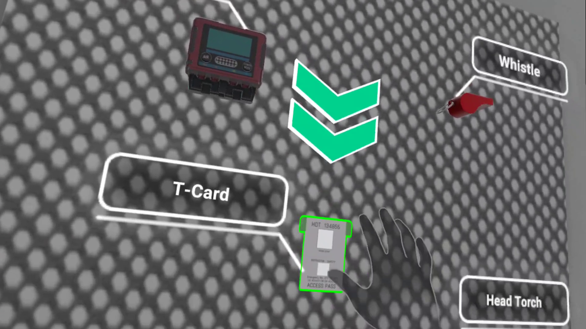 A VR training interface showing a gray textured background with several labeled items. Visible objects include a red electronic device, a red whistle, and a white access pass labeled “T-Card” highlighted in green. Other labels such as “Head Torch” and “Whistle” appear near the corresponding items. A semi-transparent virtual hand is positioned near the access pass, indicating interaction within the simulation.