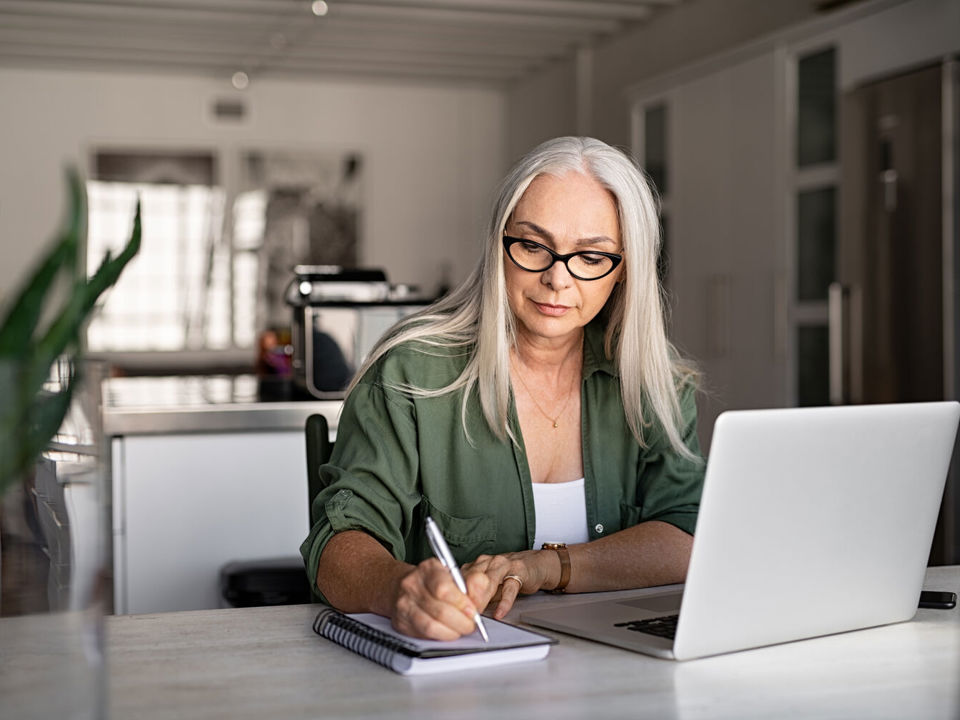 A woman working at her laptop in a home office