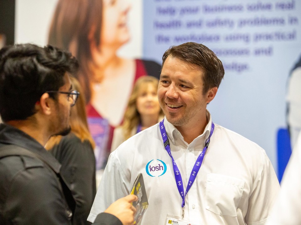 IOSH staff member talking to stand visitor at Health and Safety Event 2026