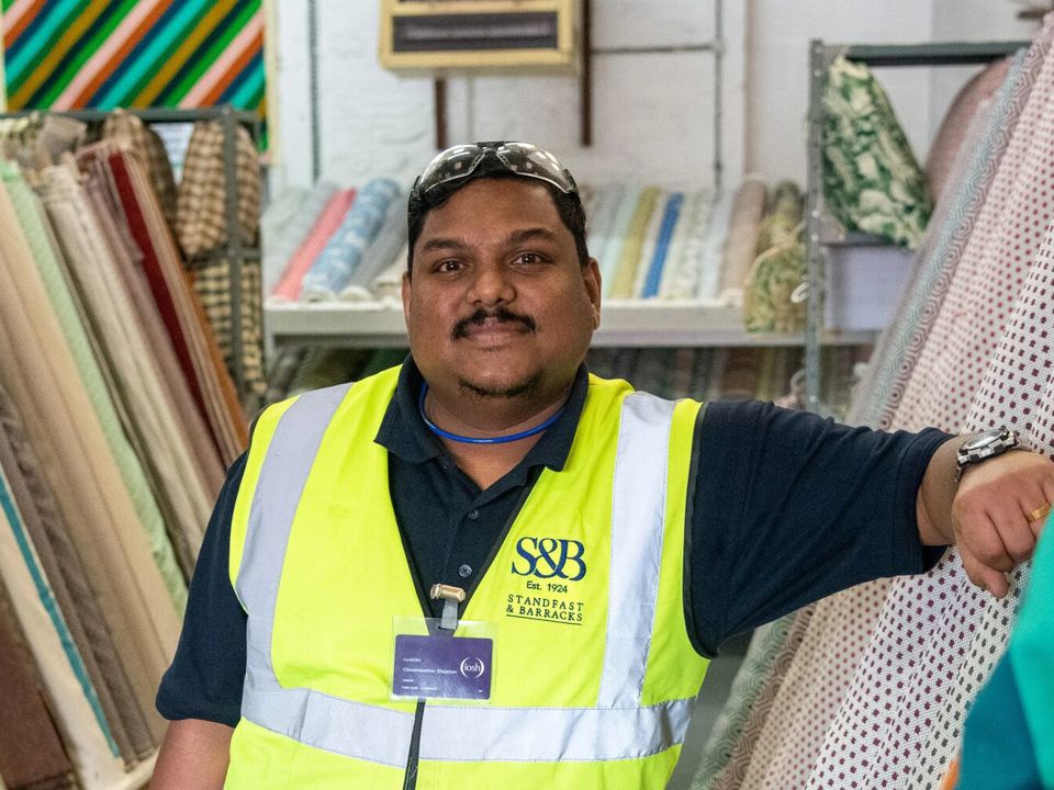 Chandrasekhar Shajahan in front of rolls of fabric