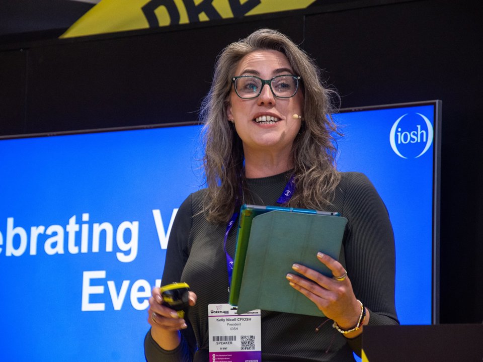 Former IOSH President, Kelly Nicol, presenting on stage at a health and safety conference