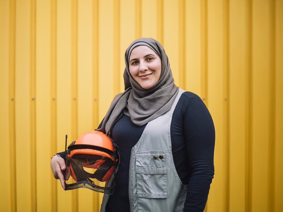 Woman in headscarf holding helmet
