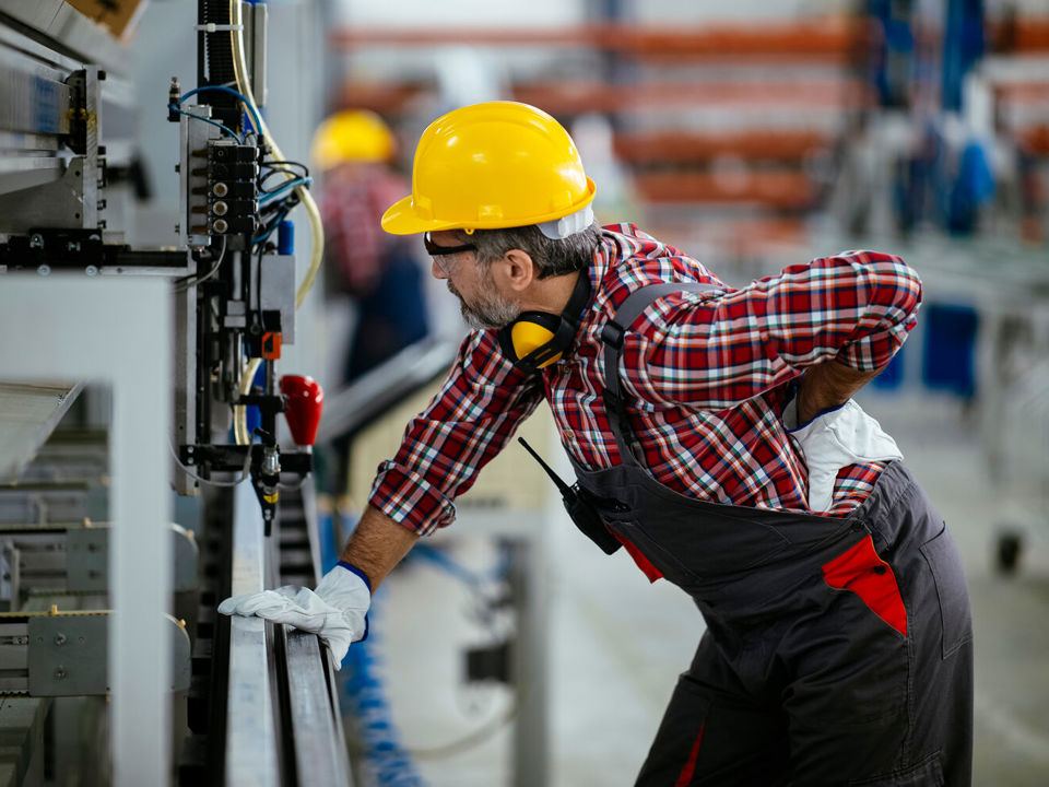 Male worker leaning over with back discomfort