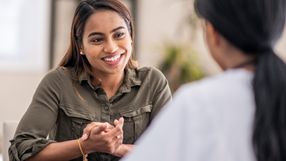 Woman smiling while having a conversation with another person