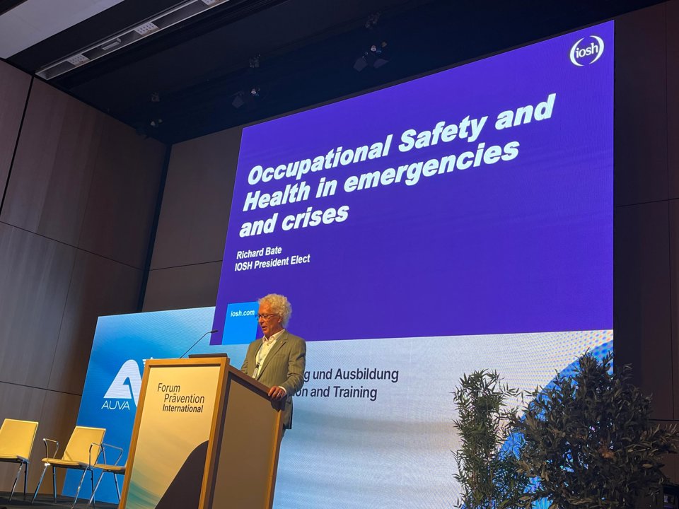 Man standing in front projector showing occupational safety and health in emergencies and crises