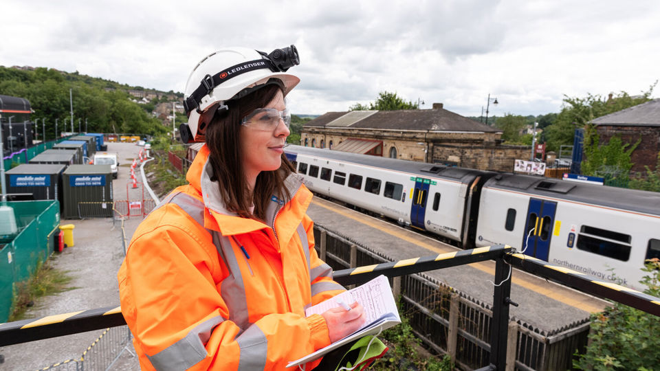 Female IOSH member in high-viz at station