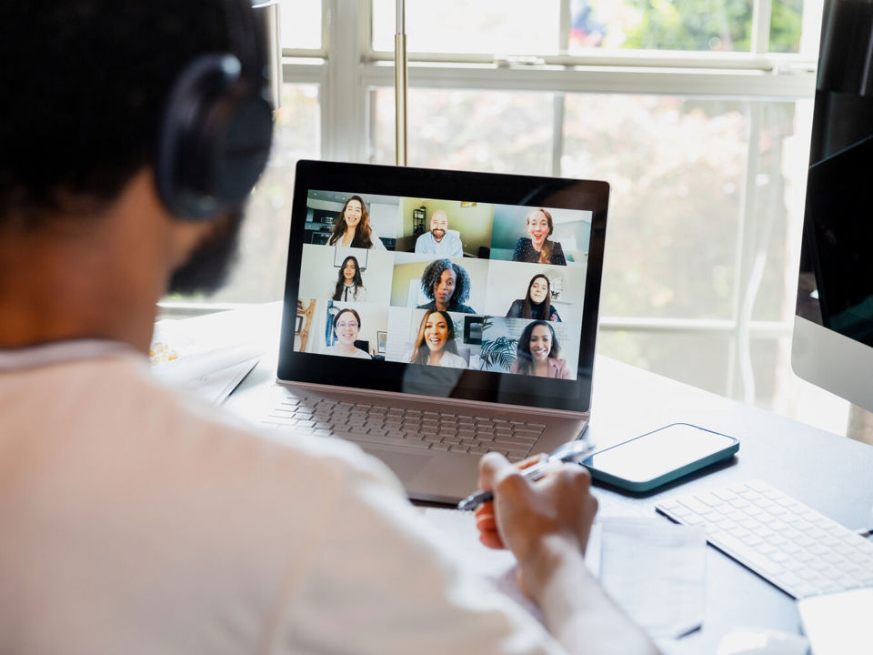 Student sitting at desk looking at laptop during virtual meeting