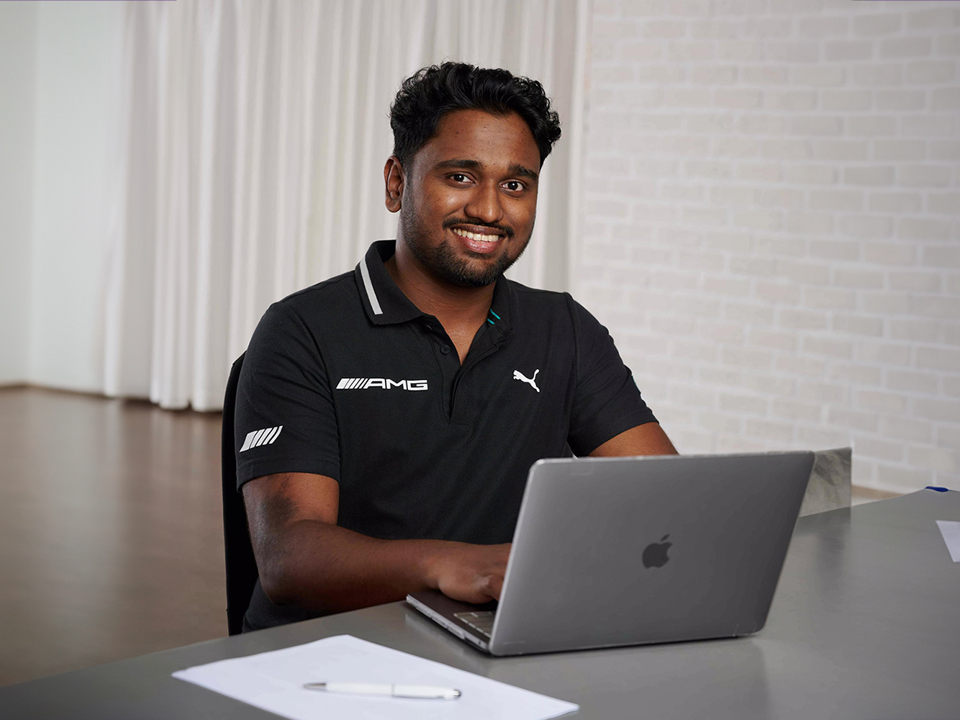 Man sat at a table and using a laptop