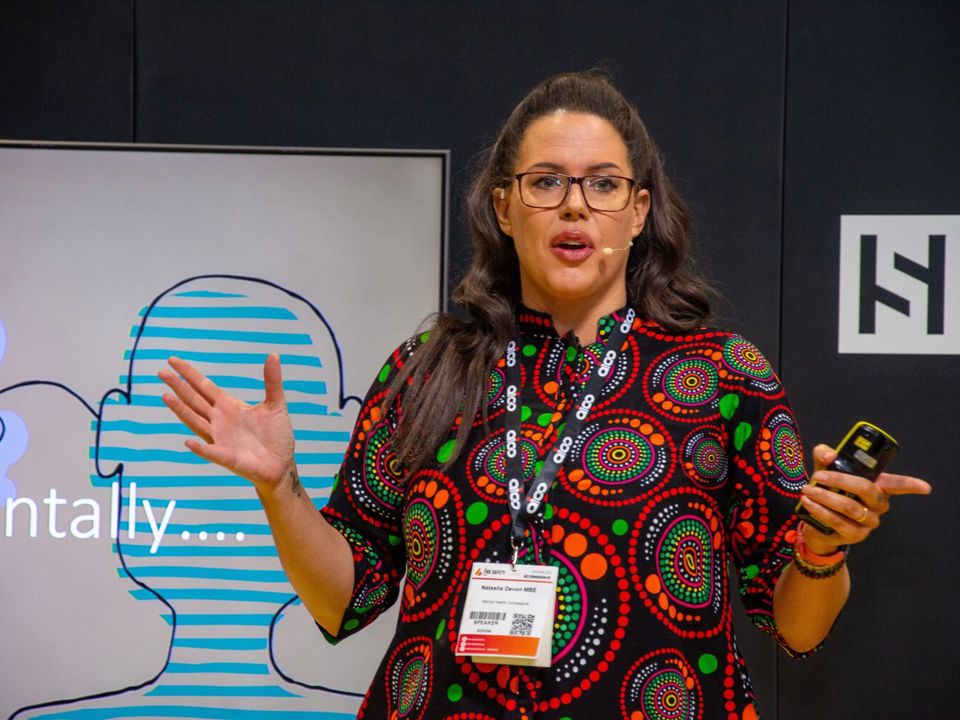 Natasha Devon speaks in front of screen