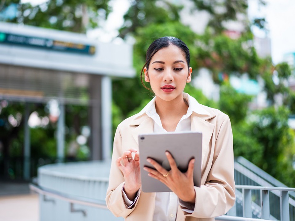 Woman using tablet computer outdoors