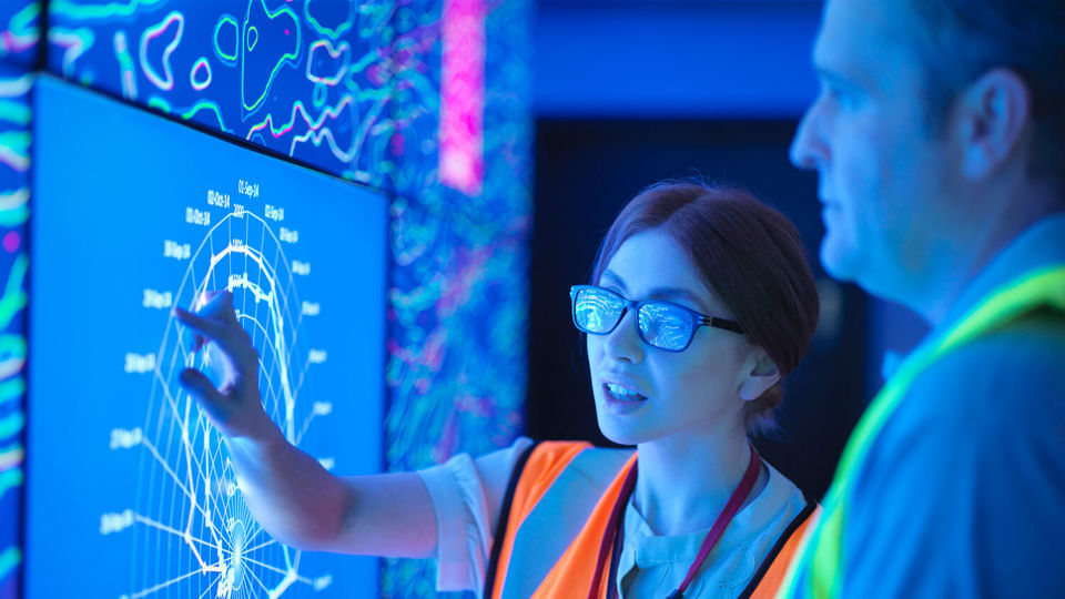 Woman operating high tech touch display in hi viz