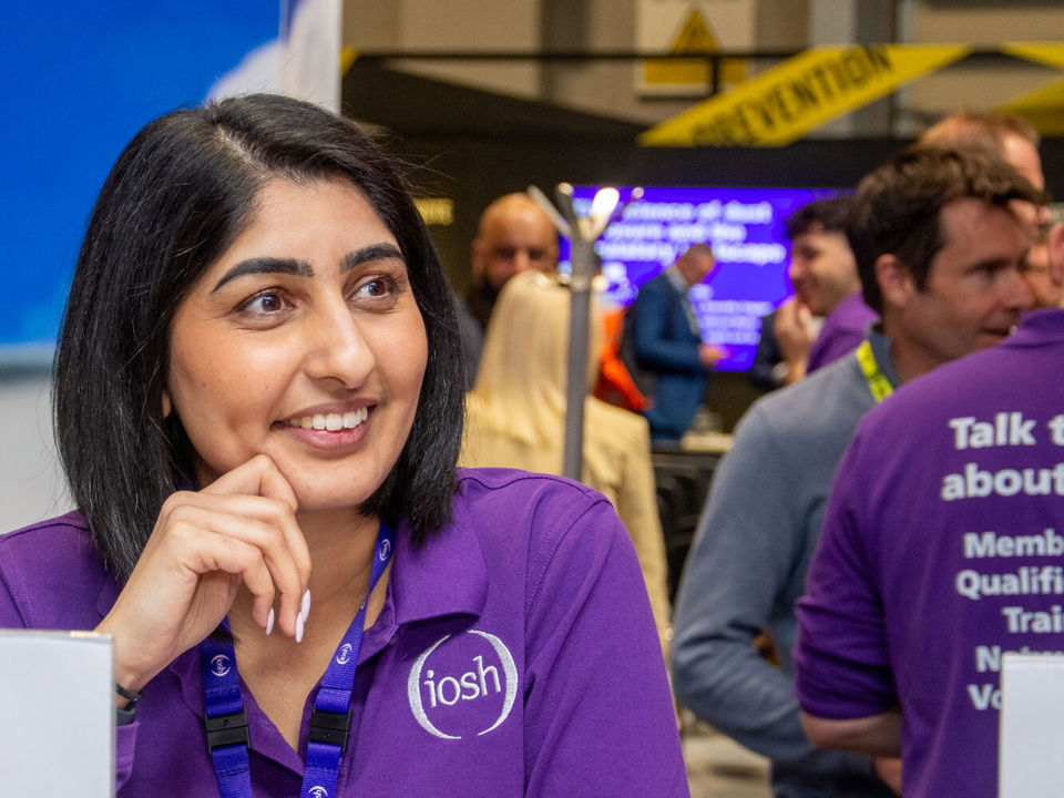 Female member of staff welcoming at IOSH exhibition stand