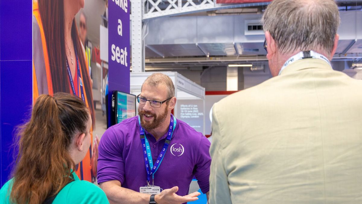 IOSH staff member answering a question at the conference stand